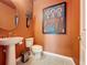 Modern powder room with pedestal sink, sleek fixtures, and vibrant wall art at 203 Silver Maple Rd, Groveland, FL 34736