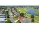 Expansive aerial of a well-kept home in a serene community with a golf course and a picturesque lake at 2068 Darlington Dr, The Villages, FL 32162