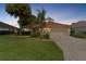 Inviting front yard with lush green lawn and mature palm trees with colorful flower beds at 2068 Darlington Dr, The Villages, FL 32162