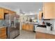 A kitchen features stainless appliances, granite counters, and light wood cabinets at 2068 Darlington Dr, The Villages, FL 32162