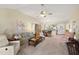 Spacious living room open to dining area with a ceiling fan and neutral colors at 2068 Darlington Dr, The Villages, FL 32162