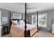 Tranquil main bedroom with four-poster bed, plantation shutters, and view of the backyard at 2068 Darlington Dr, The Villages, FL 32162