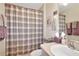 Cozy bathroom featuring a shower with a plaid curtain, updated fixtures, and decor at 20751 Queen Alexandra Dr, Leesburg, FL 34748