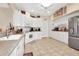 White kitchen featuring tile flooring, ample cabinet storage, and stainless steel appliances at 20751 Queen Alexandra Dr, Leesburg, FL 34748