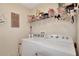 Functional laundry room with a washer, dryer, and a storage shelf above at 20751 Queen Alexandra Dr, Leesburg, FL 34748