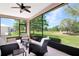 Relaxing screened porch with comfortable seating and a view of the lush green backyard at 20751 Queen Alexandra Dr, Leesburg, FL 34748