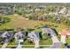 An aerial view of a neighborhood featuring well-maintained homes and landscaping and a pond in the distance at 27023 Old English Ct, Leesburg, FL 34748