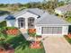 Aerial shot showcasing the home's well-maintained landscaping, screened lanai, and attached garage at 27023 Old English Ct, Leesburg, FL 34748
