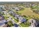 Neighborhood aerial view of a well-maintained community featuring manicured lawns, ponds, and mature trees at 27023 Old English Ct, Leesburg, FL 34748
