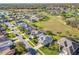 Aerial view of a community with mature trees, manicured lawns and a community park at 27023 Old English Ct, Leesburg, FL 34748