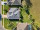 Aerial view of a home with a gray roof, well-kept lawn and mature palm trees at 27023 Old English Ct, Leesburg, FL 34748