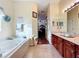 Hallway view of bathroom with double vanity and tub at 27023 Old English Ct, Leesburg, FL 34748