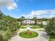 Stunning aerial view of the community clubhouse, featuring lush landscaping, circular drive, and beautiful architecture at 27023 Old English Ct, Leesburg, FL 34748