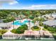 Aerial view of a resort-style pool with lush landscaping and a clubhouse on a sunny day at 27023 Old English Ct, Leesburg, FL 34748