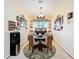 Cozy dining area featuring floral rug, ample wall decorations, natural light from window, and seating for four at 27023 Old English Ct, Leesburg, FL 34748