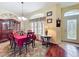 Cozy dining room featuring a red tablecloth, a decorative hutch, hardwood floors, and lots of natural light at 27023 Old English Ct, Leesburg, FL 34748