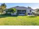 Backyard with a screened-in porch, patio, and lush green lawn in a residential home at 27023 Old English Ct, Leesburg, FL 34748