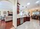 Kitchen with dark wood cabinets, stainless steel appliances and view of living and dining areas at 27023 Old English Ct, Leesburg, FL 34748
