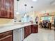 Cherry wood kitchen featuring granite countertops and a stainless steel dishwasher at 27023 Old English Ct, Leesburg, FL 34748