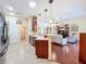 Open kitchen leading to living area, featuring breakfast bar, modern appliances, and ample natural light throughout at 27023 Old English Ct, Leesburg, FL 34748