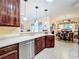Kitchen area with stainless steel dishwasher, dark wood cabinets, and a view to the dining area at 27023 Old English Ct, Leesburg, FL 34748