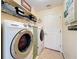 Laundry room with modern appliances and storage shelves at 27023 Old English Ct, Leesburg, FL 34748