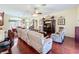 Spacious living room with hardwood floors, a ceiling fan, comfortable seating, and a view into the dining room at 27023 Old English Ct, Leesburg, FL 34748