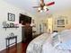 Bright main bedroom with ceiling fan, decorative wall art, hard wood floors, and a comfortable queen bed at 27023 Old English Ct, Leesburg, FL 34748