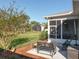 Outdoor patio featuring a metal bench, side table, and a screened-in lanai with comfortable seating at 27023 Old English Ct, Leesburg, FL 34748