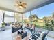 Inviting screened-in patio with stylish furniture and a ceiling fan, overlooking the lush backyard at 27023 Old English Ct, Leesburg, FL 34748