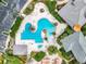 Overhead view of a unique geometric pool design, complemented by lush landscaping and resort-style amenities at 27023 Old English Ct, Leesburg, FL 34748