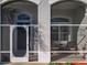 An enclosed front porch with striped chairs at 27023 Old English Ct, Leesburg, FL 34748