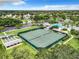 Aerial view of multiple tennis courts near a community pool, clubhouse, and lush landscaping at 27023 Old English Ct, Leesburg, FL 34748