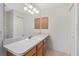 Bathroom with vanity, large mirror, and wood cabinets at 2712 Benavides Dr, The Villages, FL 32162