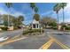 Community entrance featuring lush landscaping, a decorative gazebo and palm trees at 2712 Benavides Dr, The Villages, FL 32162