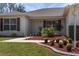 Home exterior featuring well-manicured lawn, mulch beds, and accent lighting at 2712 Benavides Dr, The Villages, FL 32162