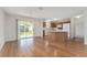 Open-concept living area featuring laminate wood flooring, a sliding glass door, and a view of the kitchen at 2712 Benavides Dr, The Villages, FL 32162