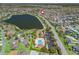 Aerial view of community pool and clubhouse area near lake and home with walking path at 3156 Vandenberg Ct, The Villages, FL 32163