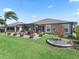 Landscaped backyard with pergola-covered patio, lush lawn and ornamental tree at 3156 Vandenberg Ct, The Villages, FL 32163