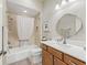 Bathroom featuring tiled shower-tub combo, vanity, and a decorative oval-shaped mirror at 3156 Vandenberg Ct, The Villages, FL 32163