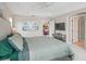 Well-lit main bedroom features a neutral color palette, large window, and ensuite bathroom entrance at 3156 Vandenberg Ct, The Villages, FL 32163