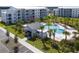 Aerial view of the apartment building next to pool and cabana area with palm trees and lush landscaping at 3180 Paradox Circle # 106, Kissimmee, FL 34746