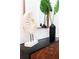 Close-up of entry decor with modern cabinet, mirror, plants, and stylish sculptural pieces at 3180 Paradox Circle # 106, Kissimmee, FL 34746