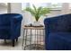 Comfortable blue chairs flank a stylish wooden and wire side table with decorative accents and sheer curtains at 3180 Paradox Circle # 106, Kissimmee, FL 34746