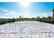 Outdoor sand volleyball court with a net and lush greenery in the background on a sunny day at 3180 Paradox Circle # 106, Kissimmee, FL 34746