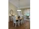 Bright dining room with wood floors, a table with four chairs, and a cabinet on the side at 3183 Hatch Ln, The Villages, FL 32162