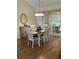 Bright dining room with wood floors, a table with four chairs, and a cabinet on the side at 3183 Hatch Ln, The Villages, FL 32162