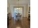 Bright dining room with wood floors, a table with four chairs, and a cabinet on the side at 3183 Hatch Ln, The Villages, FL 32162