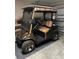 Golf cart in garage with stripped seats, storage for cooler and golf clubs. Perfect for the course! at 3183 Hatch Ln, The Villages, FL 32162