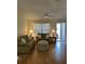 Cozy living room featuring laminate wood floors, a ceiling fan, and a window letting in natural light at 3183 Hatch Ln, The Villages, FL 32162